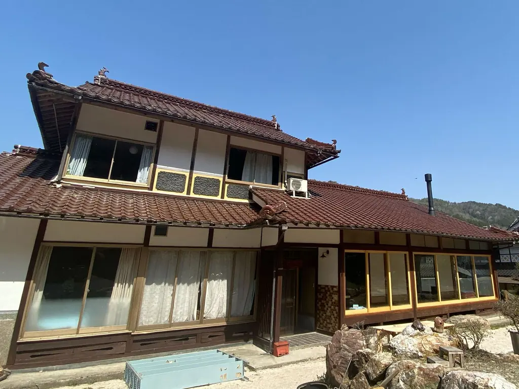青空の下に建つ、瓦屋根の二階建て。いとくるの外観