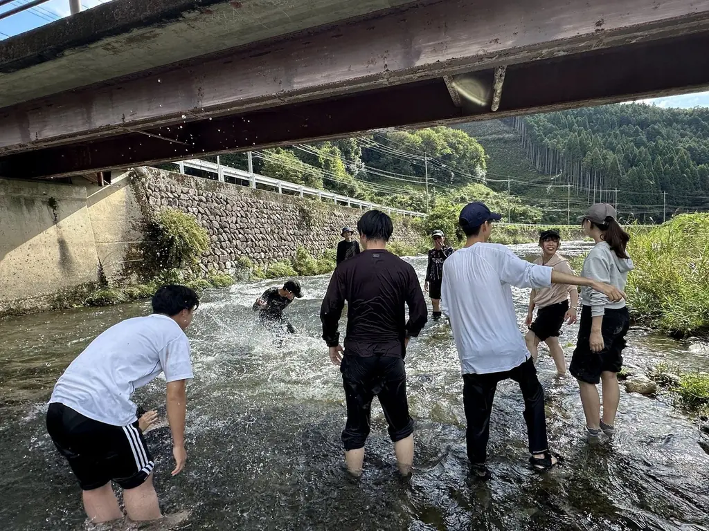 橋の下の浅い川で遊ぶ人たち