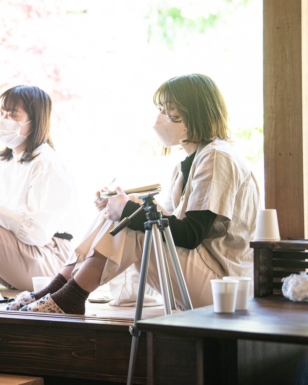 満開の桜を背に、縁側で話す人たち