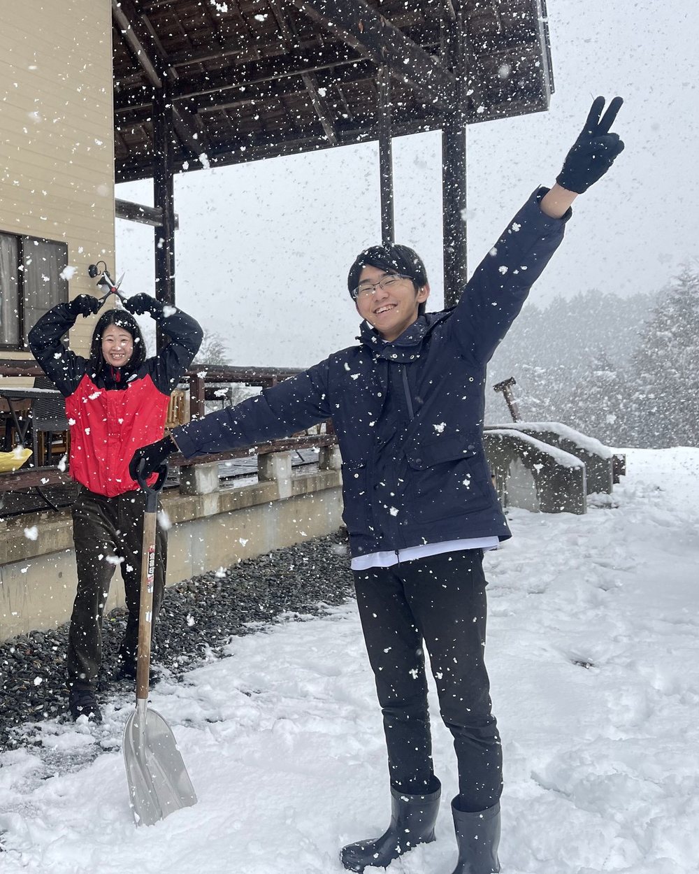 雪が舞うなか、いとくるの前で両手を上げる人たち